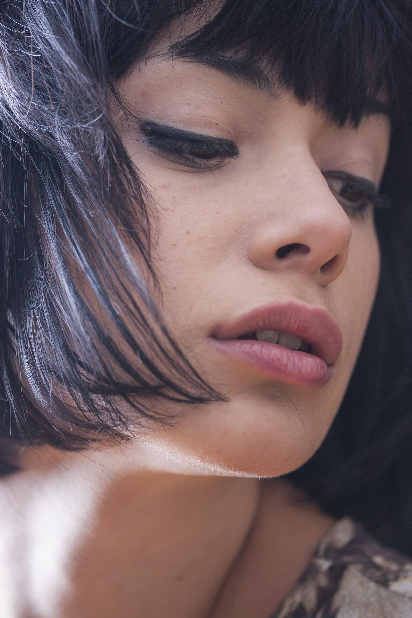 Close-up portrait showcasing the elegance and style of a brunette woman with makeup.
